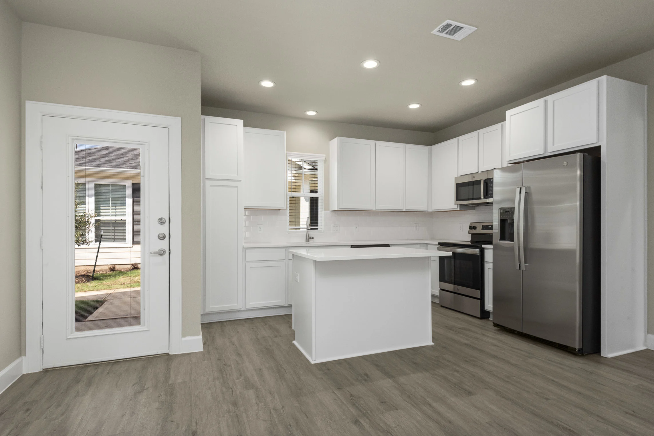 a kitchen with a white island and stainless steel appliances
